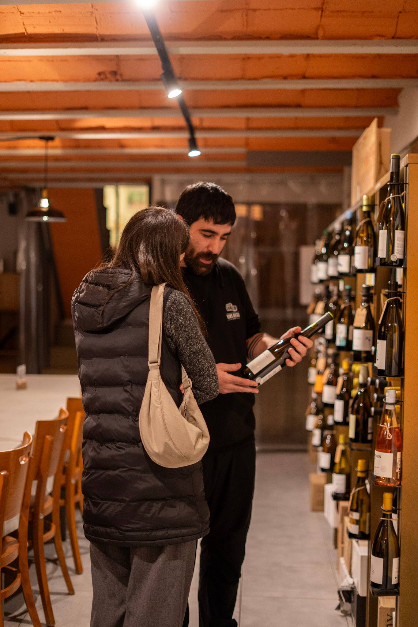 Una parella tria un vi a la botiga de Vins Riera